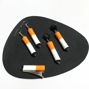 Close-up detail of quirky handmade cigarette earrings and hair clip set, unique novelty accessory.