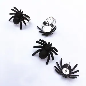 Close-up details of black spider stud earrings and adjustable rings, Halloween spooky style.