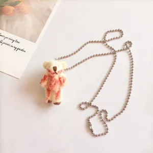 Detailopname van een schattige pluche teddybeer hanger ketting met uniek bloederig ontwerp.