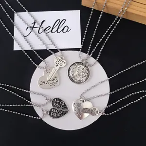 Detailed view of alloy bead chain couple necklaces with heart and key pendant engravings.