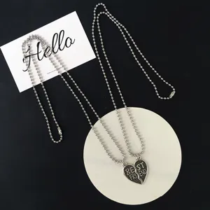 Detailed view of best friend matching split heart necklaces with silver bead chains and pendants.