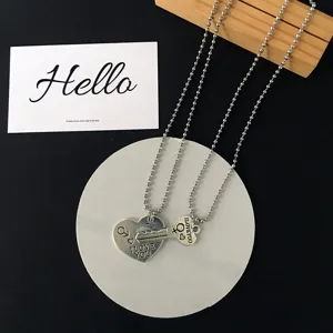 Detailed view of couple matching heart and key pendant necklaces with bead chains and love texts.