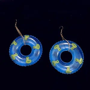 Vue détaillée de bouées de piscine bleues avec motifs de canards et chaînes dorées.