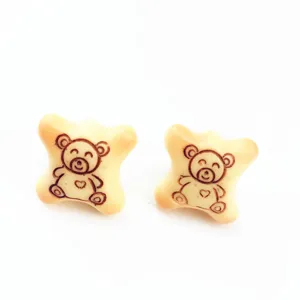 Détail en gros plan de boucles d'oreilles biscuit d'ours, design de faux aliment ludique.