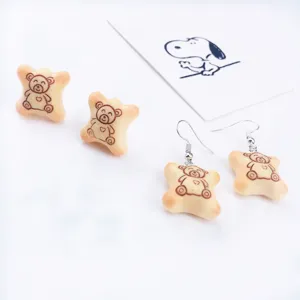 Vue de détail de boucles d'oreilles biscuit d'ours mignon, bijoux fantaisie de simulation.