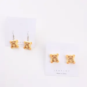 Vue détaillée de boucles d'oreilles biscuit d'ours mignon, bijoux en résine, style doux et joueur.