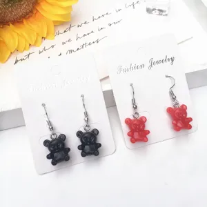 Nahaufnahme niedlicher Harz Gummibärchen Ohrringe in Schwarz und Rot, verspielter Schmuck.