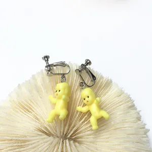 Detaillierte Nahaufnahme süßer gelber Babypuppen-Ohrclips mit kreativem tollem Design.