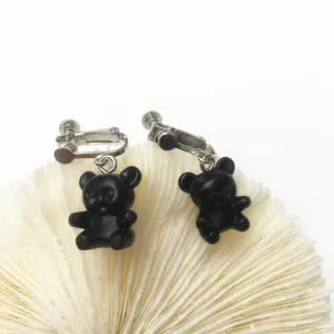 Detailaufnahme süßer schwarzer Bären-Ohrclips im verspielten japanischen Stil mit Metallverschluss.