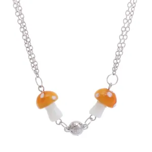 Dubbele zilveren ketting met schattige oranje paddestoelhangers en magnetische sluiting.