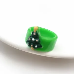 Primo piano di un anello in resina verde con grazioso dettaglio di albero Natale.