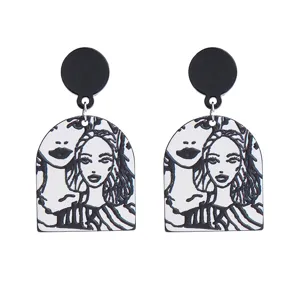 Boucles d'oreilles pendantes en acrylique portrait noir et blanc avec design artistique.