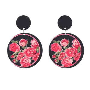 Vue détaillée de boucles d'oreilles en acrylique avec un joli imprimé floral rose noir et rouge.