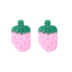 Nahaufnahme der süßen rosa Erdbeer Harzohrringe mit charmantem verspielten Biss Design.