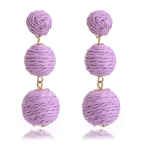Handgemaakte geweven raffia rattan bal lange oorhangers detailweergave, strandstijl.