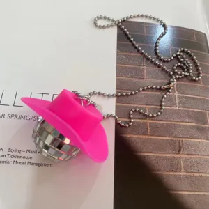 Pink cowboy hat disco ball necklace 70s retro party punk pendant accessory detail view.