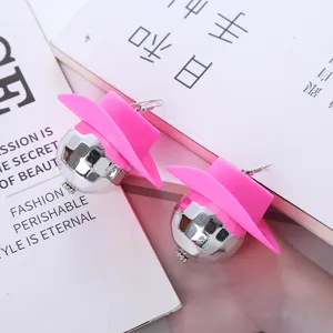 Detail view of 70s disco ball earrings featuring a pink cowboy hat, trendy punk party jewelry.