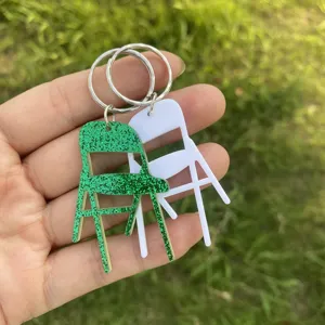 Miniatur Klappstuhl Schlüsselanhänger Detailansicht, glitzernd grüne und weiße Acryl Anhänger.