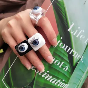 Nahaufnahme Detail modischer Acrylharz-Viereckringe mit realistischen Puppenwimpern und Augapfel.