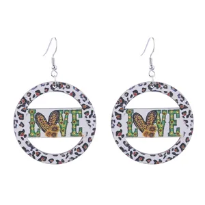 Detailed shot of trendy wooden leopard print hoop dangle earrings featuring love text.