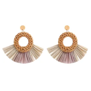 Handgemaakte geweven rattan rafia waaier kwast oorbellen detail opname, boho stijl.