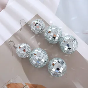 Primo piano di orecchini lunghi a sfera disco argento, design a specchio lucido.