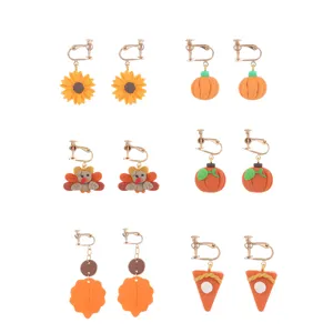 Nahaufnahme handgemachter Fimo Thanksgiving Ohrringe mit niedlichen Herbst Kürbis und Truthahn.