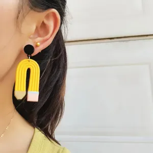 Detailaufnahme süßer kreativer Bleistift-Ohrringe aus Fimo am Ohr des asiatischen Modells.