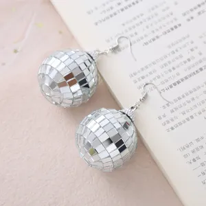 Primo piano dettagliato di orecchini a sfera a specchio, accessorio per feste scintillante.