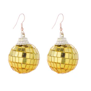 Primo piano dettaglio di orecchini a sfera disco dorati per accessori da festa retrò.