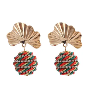 Gros plan détaillé des boucles d'oreilles feuille de ginkgo et boule tissée strass.