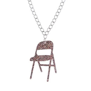 Détail en gros plan du pendentif chaise pliante acrylique marron pailleté chaîne.