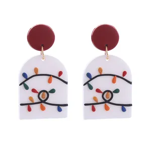 Detailansicht von Weihnachts-Ohrhängern aus Polymerlehm mit bunten Lichterketten-Motiven.