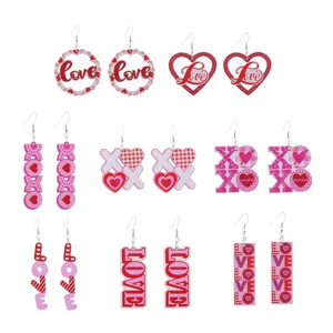 Detailansicht von Valentinstag Liebesherz Holzohrringen mit süßen Buchstaben und Mustern.