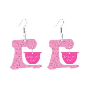 Pink acrylic stand mixer earrings with cute sprinkles design and BAKE MY DAY print detail.