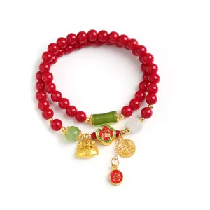 Rotes Perlenarmband zum Jahr des Drachen mit süßen goldenen Glücksanhängern für Damen.