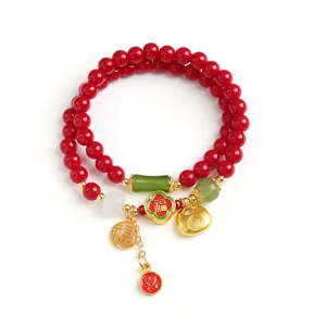 Rotes Kristallperlenarmband mit glücklichen Goldanhängern für das chinesische Neujahr.