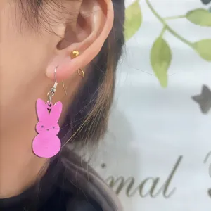Detailaufnahme von süßen rosa Holz-Osterhase-Ohrringen am Ohr getragen, süß.