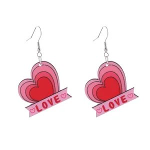 Nahaufnahme der romantischen rosa Herzen Ohrringe mit LOVE Buchstaben Druck im Detail.
