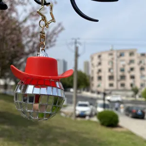 Nahaufnahme des kreativen Disco-Spiegelballs mit rotem Cowboyhut Auto Hängeanhänger Detail.