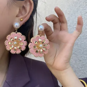 Boho handgefertigte rosa Raffia Blumen Ohrringe mit Perle und goldenen Metalldetails.