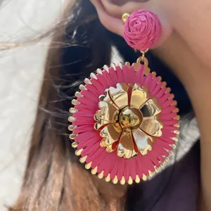 Boucles d'oreilles pendantes en raphia rose et metal, style vacances d'ete chic et fleuri.