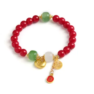 Elegantes rotes Kristallperlenarmband mit goldenen Glücksanhängern und Jadeperlen für Feste.