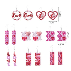 Detail Ansicht von Valentinstag Holz Ohrringen mit Herz und XOXO Buchstaben gedrucktem Motiv.