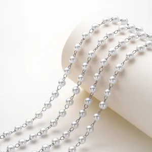 Dettaglio catena di perle per gioielli fai da te, elegante metallo argentato con perle bianche.