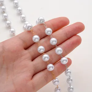 Dettaglio gioiello DIY fatto a mano con catena di perle bicolore oro e argento materiali.