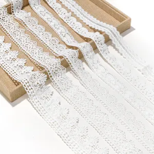 White lace trim detail showing delicate hollow embroidery patterns on rustic jute tray background.