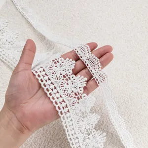 Close-up shot of white lace trim, delicate hollow embroidery details for DIY crafts