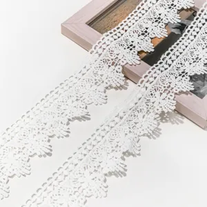 Close-up detail of white lace trimming, delicate hollow-out embroidery for DIY crafts and hair accessories.