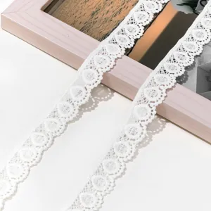 Detailed view of the white lace embroidery trim, delicate hollow mesh fabric for DIY crafts.